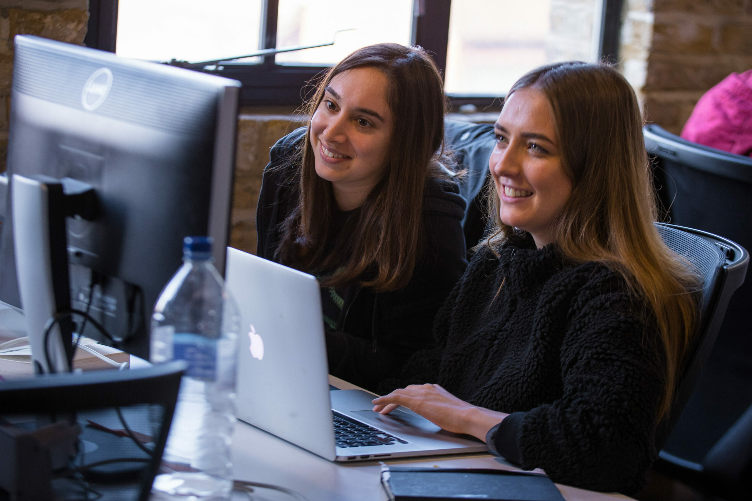 Two women coding together